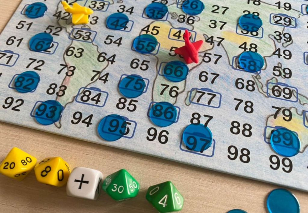 Ausschnitt aus Hin und weg: Man sieht ein Teil des Spielfelds und die W+rfel, aus denen Aufgaben gebildet werden