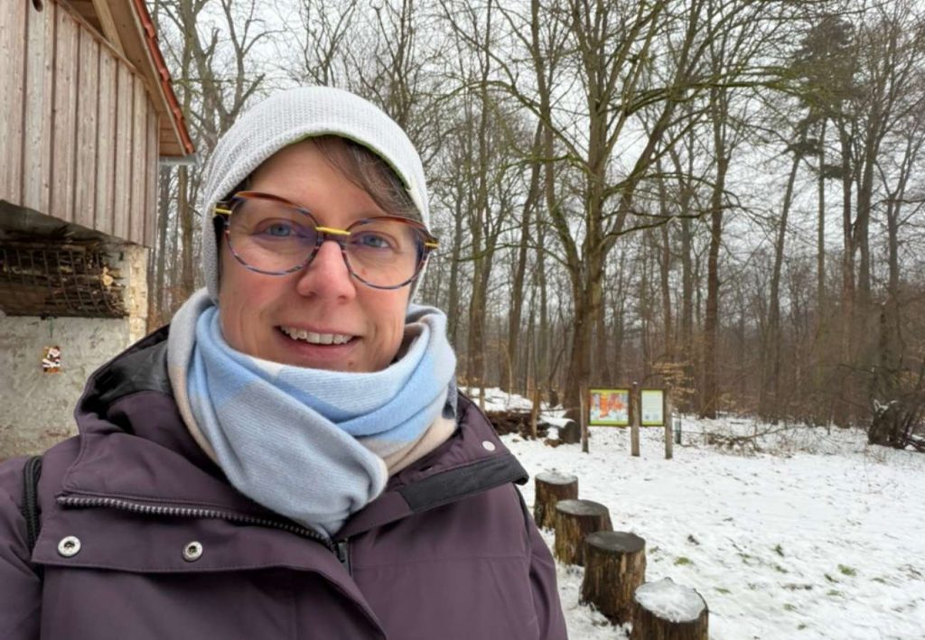 Sabine Landua in einer verschneiten Waldlandschaft